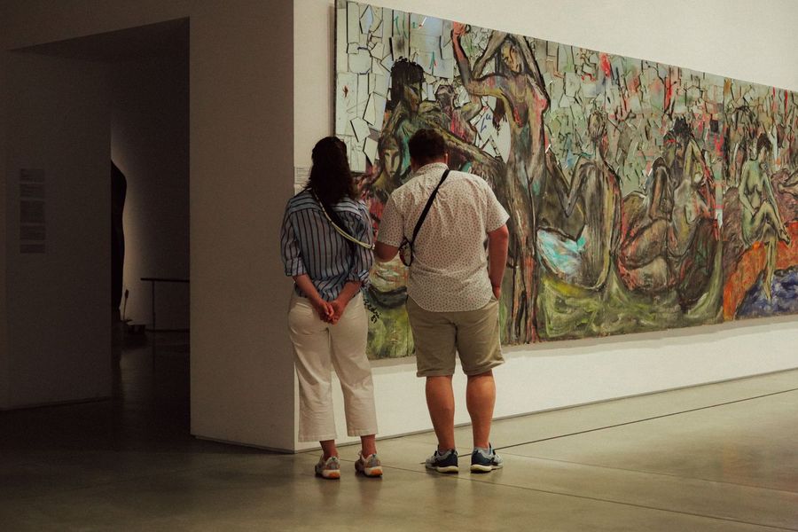 Besucher vor einem grossen Gemälde in einer Ausstellung