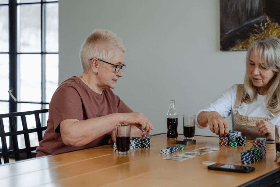 Zwei ältere Frauen spielen Karten