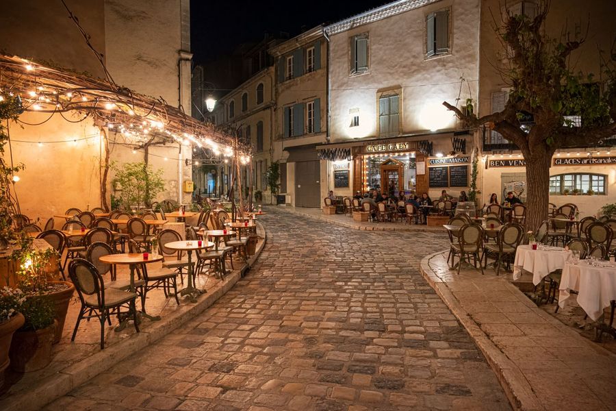 Gedeckte Tische in einer Altstadtgasse am Abend